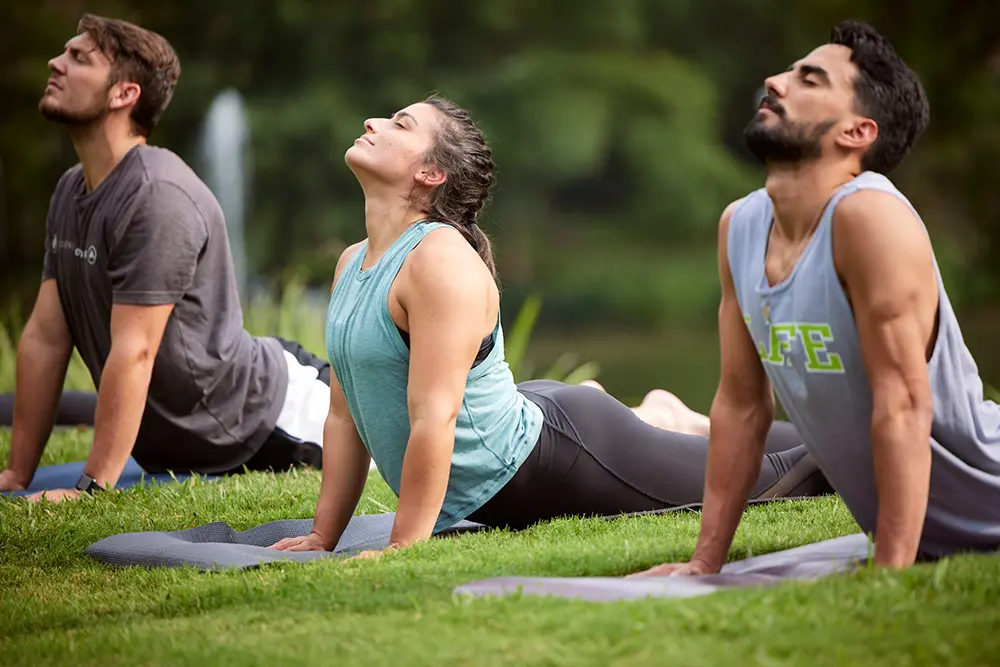 Group of people practicing outdoor yoga, symbolizing how wellness meets lifestyle with On Take Water for better hydration, energy, and balance.